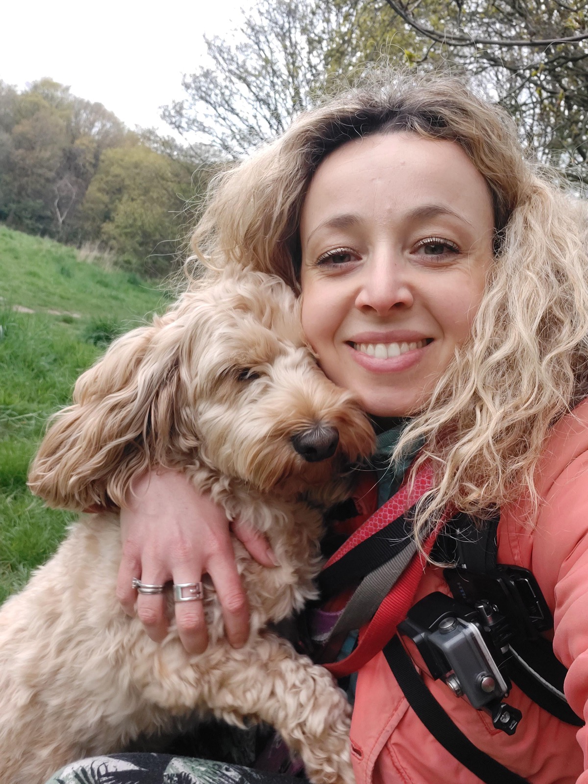 Elodie smiling with a cockapoo cuddled in her arms on a North Leeds walk